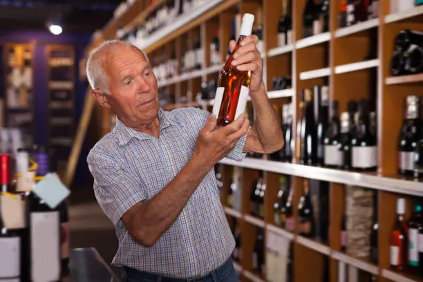 Polite man visiting winehouse in search of bottle of good wine
