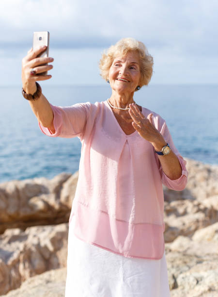 istock Mature woman taking selfie on beach 1156418005