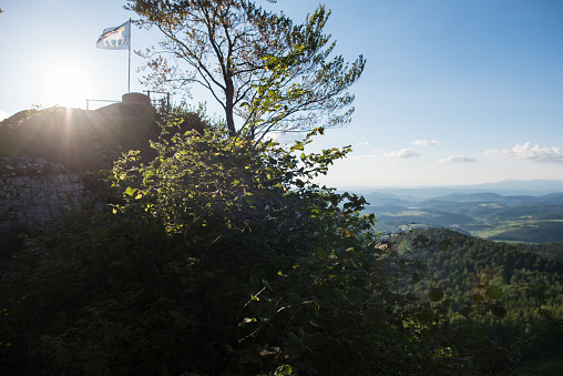 An American Flag being flown against a blue sky high in the mountains.