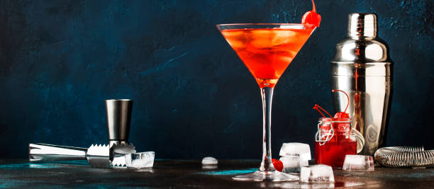 istock Classic alcoholic cocktail Manhattan with bourbon, red vemuth, bitter, ice and cocktail cherry in glass, gray bar counter background, place for text, selective focus 1156422070