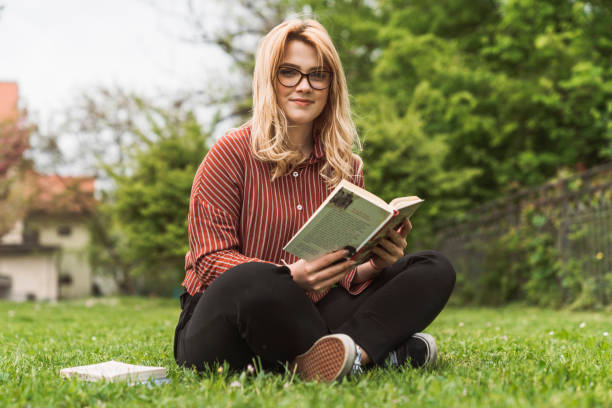 istock Smiling student reading in the park 1156426032