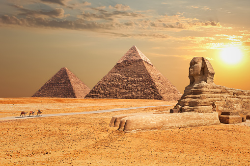 The Sphinx and the Pyramids at sunset in Giza.