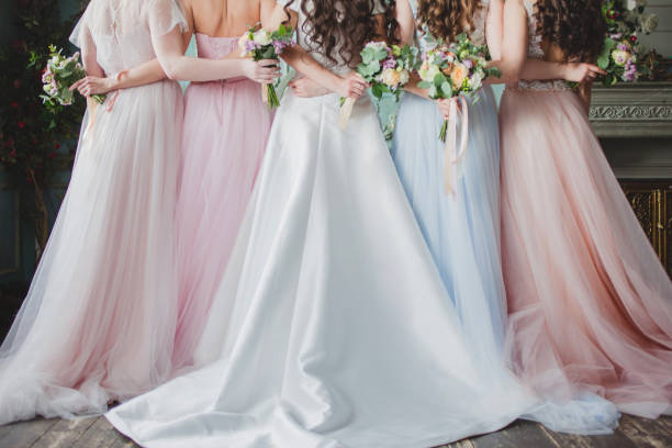 Beautiful young woman bride with friends. A wedding celebration Beautiful young woman bride with friends. A wedding celebration, ladies in splendid dresses, Back view kruis stock pictures, royalty-free photos & images