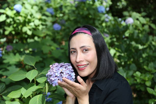 istock Woman smelling a Hydrangea plant. 1156427615