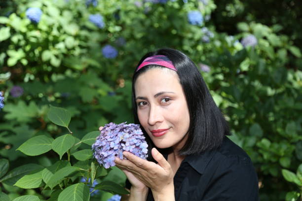 istock Woman smelling a Hydrangea plant. 1156427704