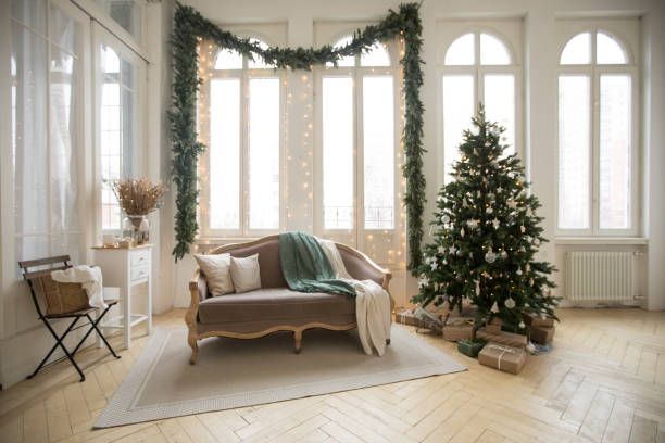 Sofa and Christmas tree near windows stock photo