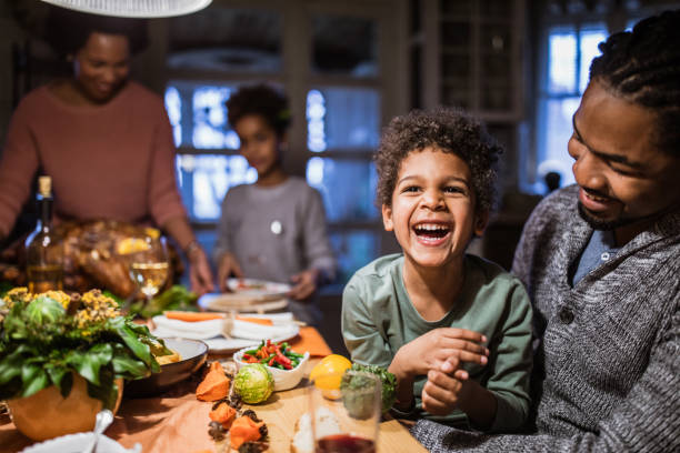 istock Cheerful black boy with his father at dining table. 1156428659
