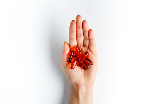 Health themes. Female hand with fish oil gelatin capsules. Omega-3