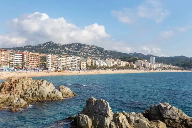 Many hotels and beach town of Lloret de Mar, Spain. People relax on the beach, bathe, swim and sunbathe