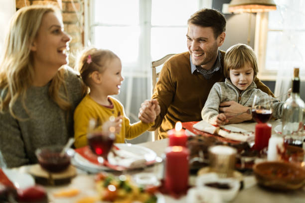 istock Happy parents enjoying with their kids at dining table. 1156432453