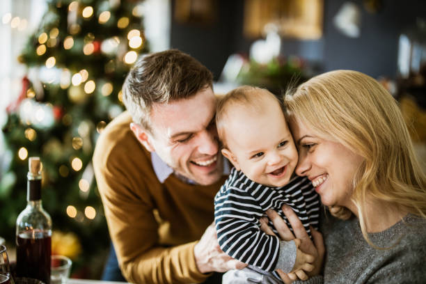 Affectionate parents and their baby son on New Year at home. Happy parents enjoying with their baby boy during New Year's day at home. baby new years eve new years day new year stock pictures, royalty-free photos & images