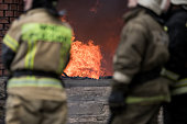 Firefighter rescue working from burning building  in fire and smoke  incident.