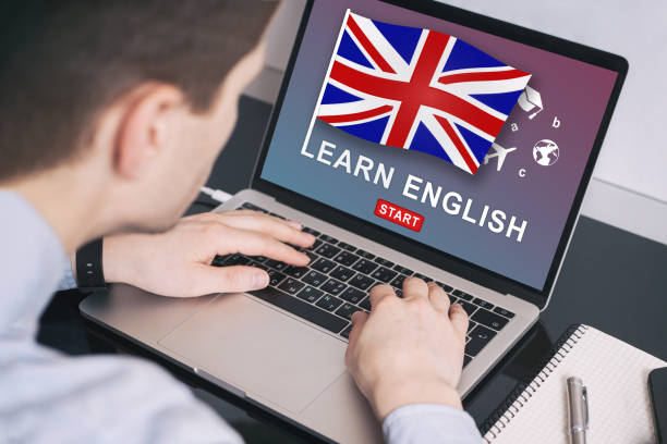 istock Man working on laptop with LEARN ENGLISH on a screen. Education Learning English Language School Concept 1156440015