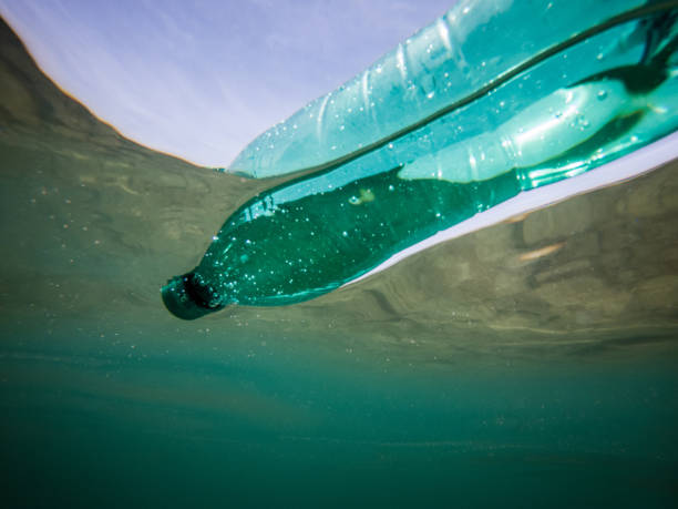 istock Green disposable plastic water bottle floating in the ocean 1156443300
