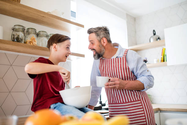 istock Mature father with small son indoors in kitchen, making pancakes. 1156444960