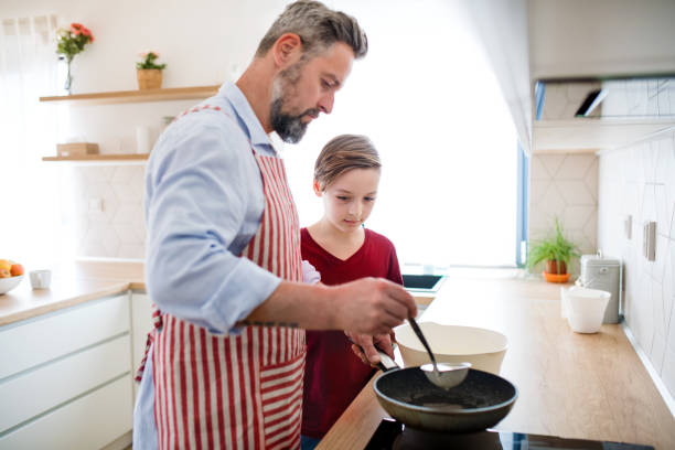 istock Mature father with small son indoors in kitchen, making pancakes. 1156444980