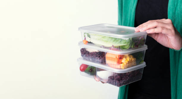 istock Hand holding fresh healthy diet lunch box with vegetable salad on white background with copy space. 1156445109