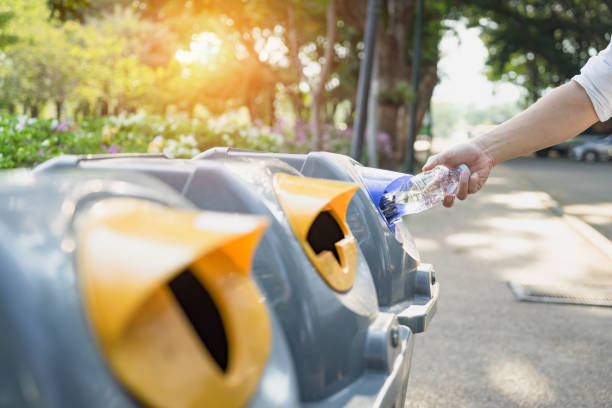 istock Waste management, Man throwing plastic bottle into recycle bin. Waste separation rubbish before drop to garbage bin to save the world, environment care. Pollution trash recycling management concept. 1156446782