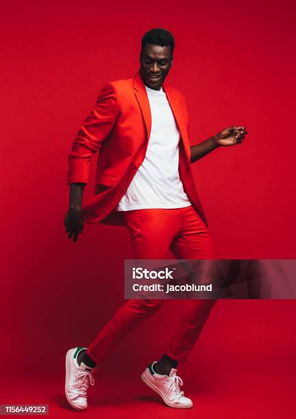 Hombre Bailando Sobre Fondo Rojo Foto de stock y más banco de imágenes de Hombres - Hombres, Bailar, Moda