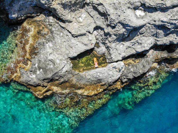istock Woman floating in pool formed in nature. 1156450178