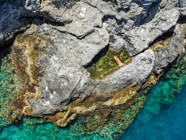 istock Woman floating in pool formed in nature. 1156450428