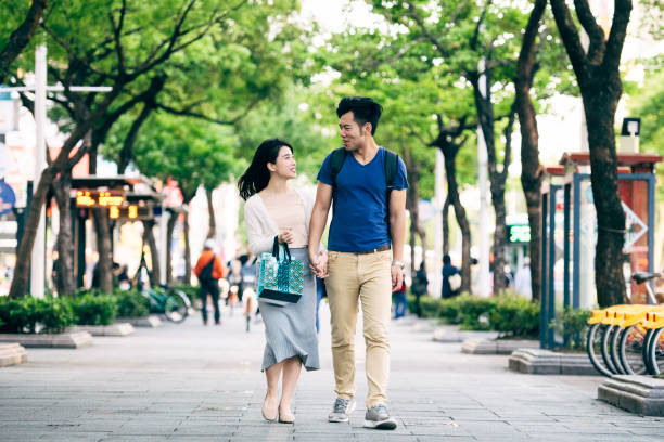 Happy heterosexual couple talking and walking with shopping bags, travel, weekend, vacation, city life