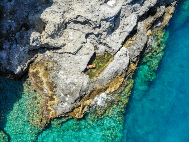 istock Woman floating in pool formed in nature. 1156452136