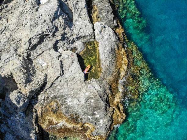 istock Woman floating in pool formed in nature. 1156452374