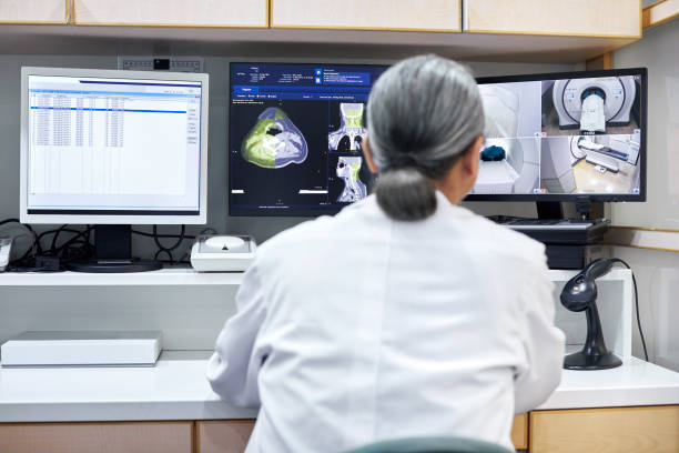 istock Mature male doctor analyzing CAT scan on monitors 1156453961