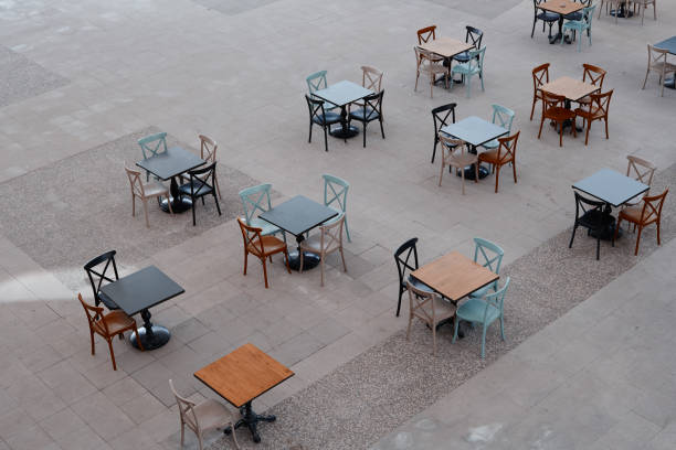 istock Sidewalk cafe chairs and tables in a row from high angle 1156454474