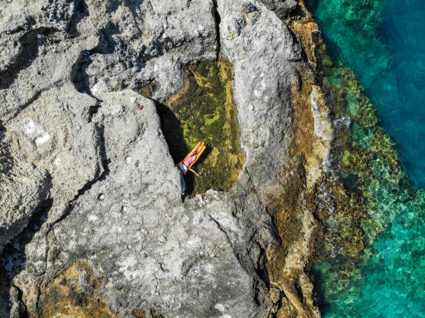 istock Woman floating in pool formed in nature. 1156455539