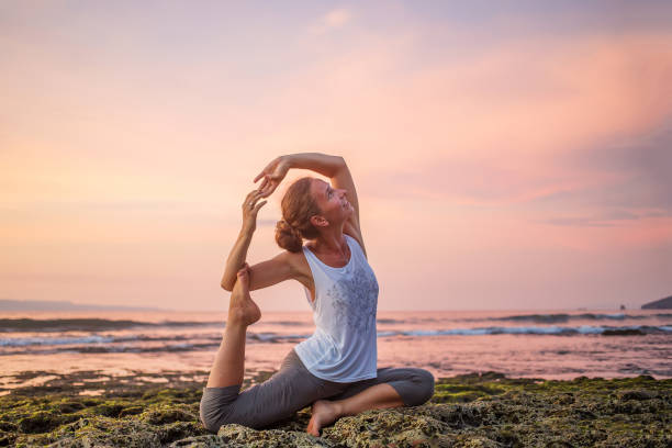 istock Caucasian woman practicing yoga at seashore 1156455752