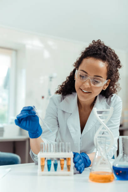 istock Delighted young woman looking at the test tubes 1156456255