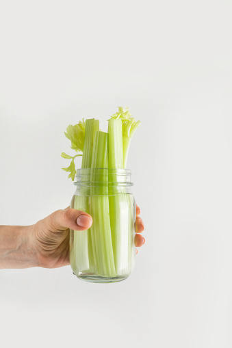 Fresh celery in mason jar with water. Save summer harvest. Storage. Zero waste concept. Lifehack save vegetable fresh.