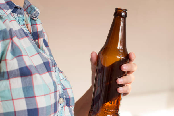 istock young woman holding an empty beer bottle 1156458375