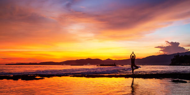 Caucasian woman practicing yoga at seashore