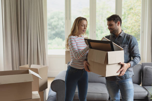 istock Couple holding cardboard box in new home 1156461178