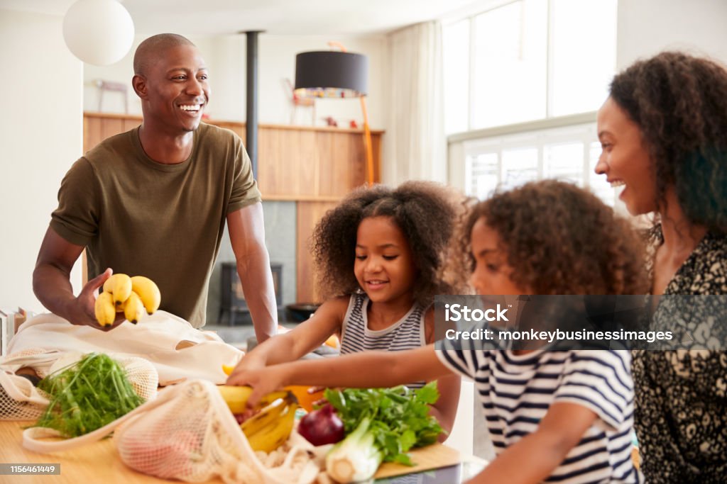 Family Returning Home From Shopping Trip Unpacking Plastic Free Grocery Bags Groceries Stock Photo