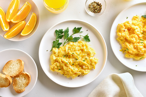 Plate of scrambled organic eggs served with bread toasted on a griddle pan.