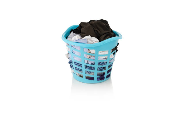 istock Clothes in a laundry wooden basket on white background 1156461594