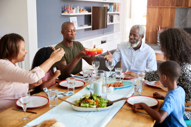 istock Multi-Generation Family Sitting Around Table At Home Enjoying Meal Together 1156463093