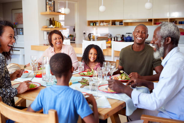 istock Multi-Generation Family Sitting Around Table At Home Enjoying Meal Together 1156463377