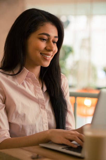 istock Smiling young woman working on the laptop 1156464421