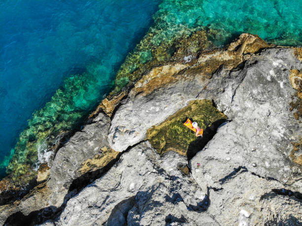 istock Woman floating in pool formed in nature. 1156464484