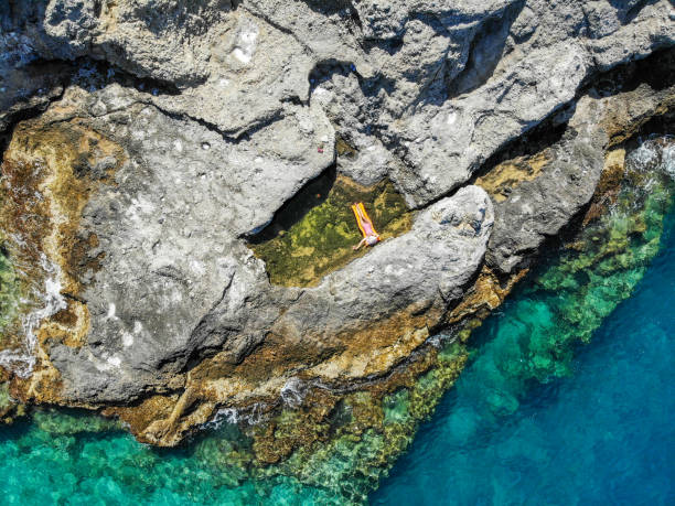 istock Woman floating in pool formed in nature. 1156464756