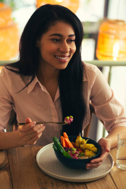 istock Smiling woman looking away while eating her meal 1156464757