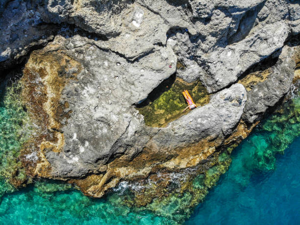 istock Woman floating in pool formed in nature. 1156465647
