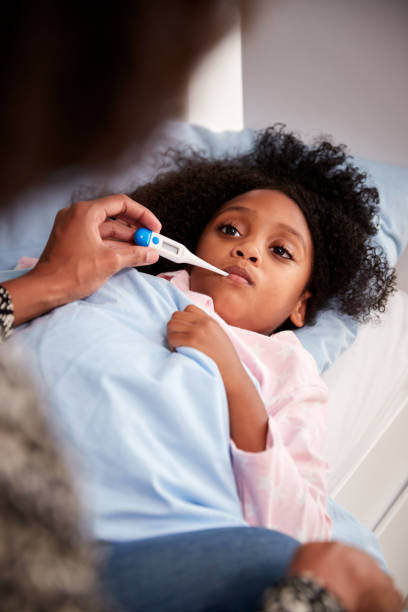 istock Mother Caring For Sick Daughter Ill In Bed Taking Temperature With Thermometer 1156465697