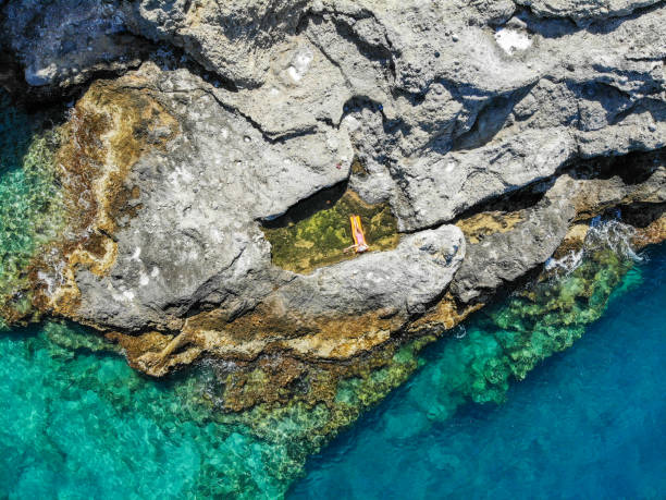 istock Woman floating in pool formed in nature. 1156466070