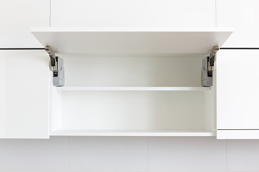 opened white kitchen cabinet with empty shelf